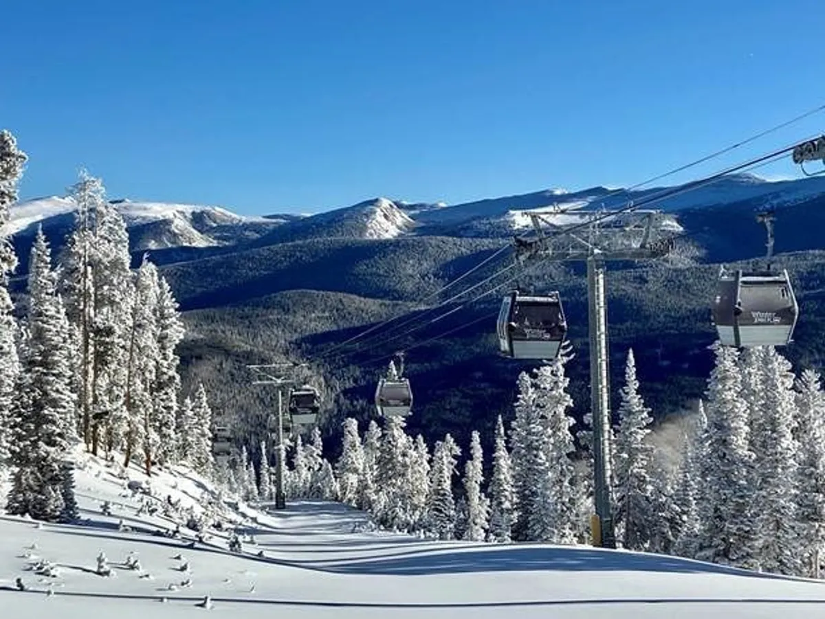 A stunning scene of gondola lifts gliding above snow-covered slopes with a dramatic mountain range in the background. The landscape is pristine and the mood is serene, evoking the thrill of ski and snowboard adventures at Winter Park Resort.